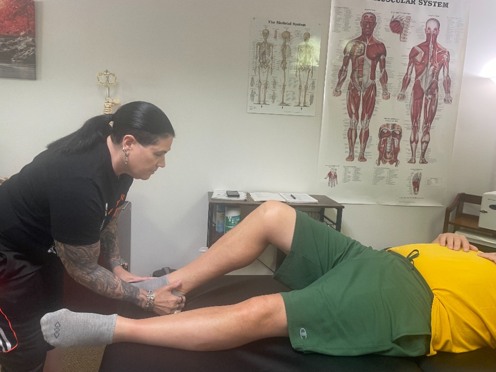 Luanne performing a hands-on MAT assessment on a client's lower leg and ankle